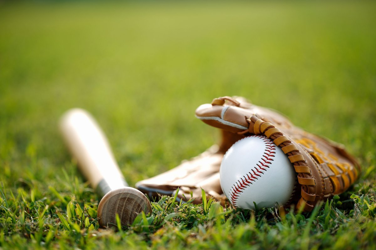 Baseball, bat, and glove laying in the grass