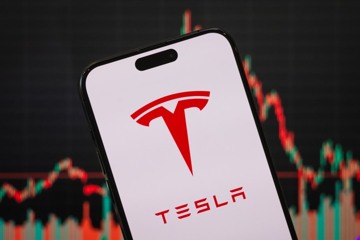 In this photo illustration, the Tesla logo is displayed on a smartphone screen