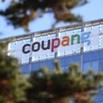 A general view shows the logo of South Korean online delivery service Coupang, at a building housing the headquarters of Coupang in Seoul on December 9, 2025. South Korean police raided the Seoul headquarters of e-commerce giant Coupang on December 9, over a recent data leak believed to have affected almost two-thirds of the country's population.
