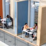 Groups of college students sitting in booths, discussing