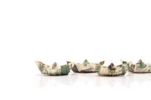 row of paper ships from dollar banknotes