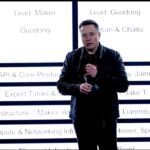 Elon Musk stands in front of xAI's new org chart