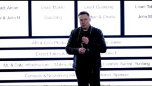 Elon Musk stands in front of xAI's new org chart