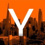 Large white "Y" overlaid on an orange-tinted skyline of San Francisco