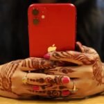 red iPhone held in two hands