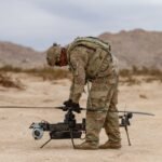 A US soldier prepares an Anduril-built drone for flight during a training exercise.