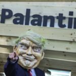 An activist dressed as U.S. President Donald Trump stands in front of a mock Trojan horse