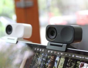 Duas pequenas webcams retangulares presas na parte superior da tela de um laptop, uma branca e outra preta