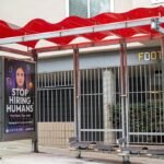 Bus stop shelter with red canopy and ad for Artisan AI reading "Stop Hiring Humans" and "For Work They Hate" on city sidewalk, San Francisco, California, September 30, 2025. (Photo by Smith Collection/Gado/Getty Images)