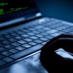 Hacker using laptop. Lots of digits on the computer screen.