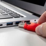 A USB flash drive stick and a laptop computer.
