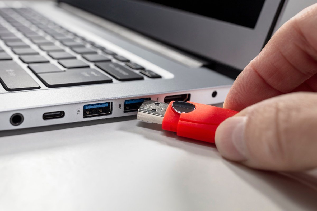 A USB flash drive stick and a laptop computer.