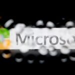 The Microsoft Corp. logo is seen through water droplets.